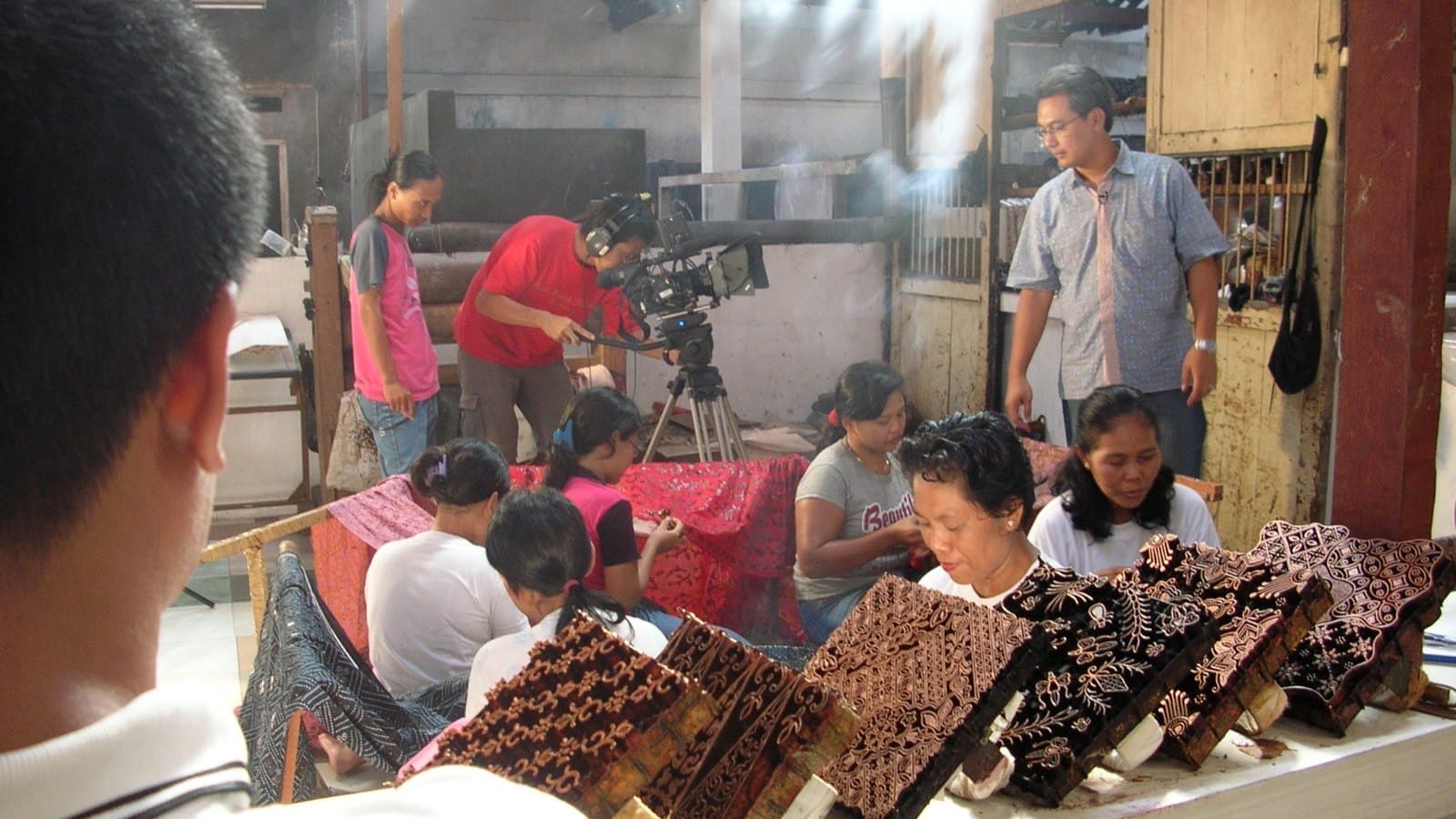 Juru kamera merekam para pembatik yang sedang bekerja di rumah batik
